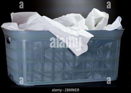 Linen prepared for washing in a basket with washing means. Close up. Stock Photo