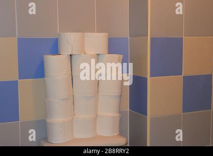 Closeup stack of toilet paper in restroom, people hoarding toilet paper and other supplies due to fear of coronavirus pandemic, hoarding concept Stock Photo