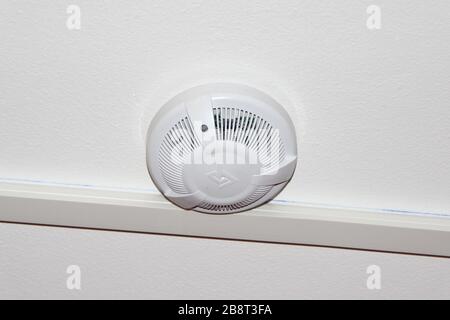 White smoke detector on the ceiling. Fire safety and alarm concept. Stock Photo