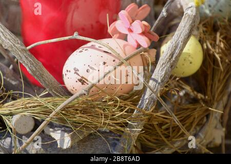 small part of easter decoration with eggs and candle in wooden basket, easter decoration in spring sun Stock Photo