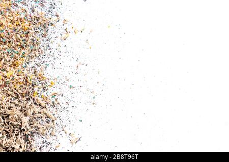 Small wooden shavings from colored pencils. Spraying from left to right. Copy space and white background. Stock Photo