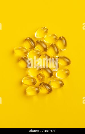 Omega 3 pills. Fish oil supplement capsules on yellow background. Top view. Stock Photo
