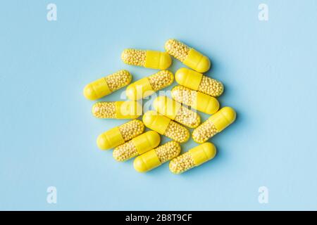 Vitamin capsules. Vitamin C pills on blue background. Top view. Stock Photo