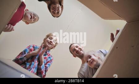 A large family opens the parcel and clap their hands. Stock Photo
