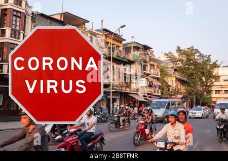 Hanoi, Vietnam - March 20th 2020: Concept image with large red Coronavirus warning sign in front of city and locals, travel restriction concept Stock Photo