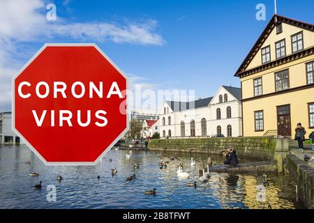 Reykjavik, Iceland - March 20th 2020: Concept image with large red Coronavirus warning sign in front of Lake Tjörnin, travel restriction concept Stock Photo