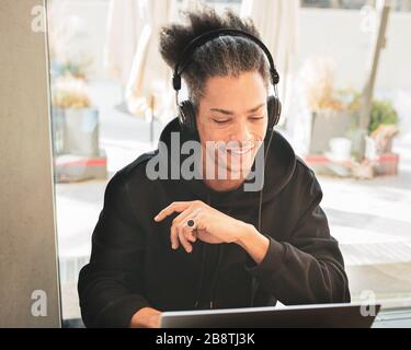 Creative afro american man, with weird hair, is studying and creating new content for his personal blog, latin american working on web project, lifest Stock Photo