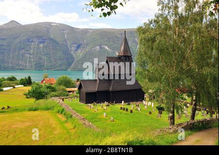 A stunning view of a Norwegian stave church surrounded by lush green ...