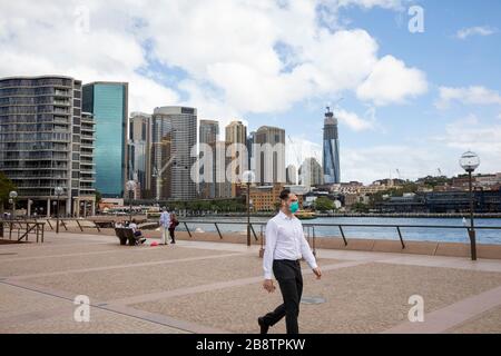 Sydney city centre, Australia. Monday 23rd March 2020. Office worker wearing mask at lunchtime in Circular Quay. Credit Martin Berry/Alamy Live News