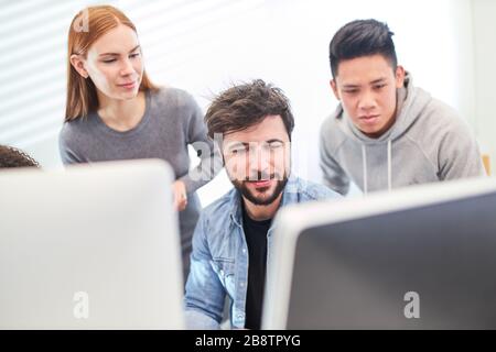 Together, web designers develop a design concept for a website on a PC Stock Photo