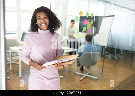 Young African business woman as a start-up founder with documents in the office Stock Photo