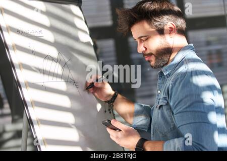 Creative web designer or graphic designer makes a design sketch on the flipchart Stock Photo