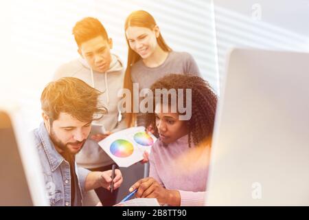 Team of graphic designers plans color design together in the office at the workplace Stock Photo