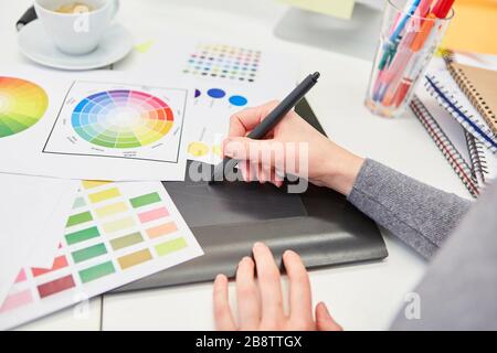 Hand from graphic designer draws a draft with pen on the tablet computer Stock Photo