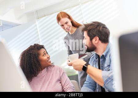 Young web designer team has a coffee break on the computer in the office Stock Photo