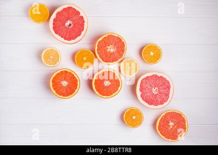 Composition with halves of different citrus fruits on white wooden background Stock Photo