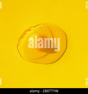 Raw egg on yellow background, top view. Stock Photo