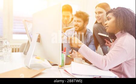 Team of web designers in the office working on a computer Stock Photo