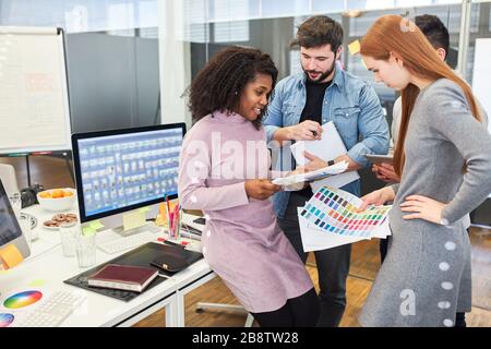 Graphic designers and web designers work together with web developers in an internet agency on an app project Stock Photo