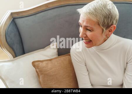 Cheerful Caucasian short-haired elderly lady looking away Stock Photo