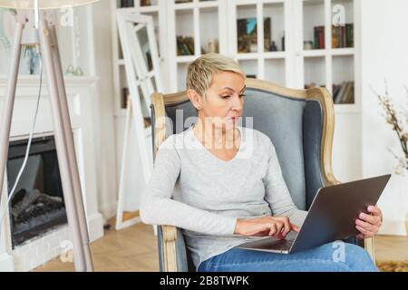 Serious blonde lady typing on a computer Stock Photo