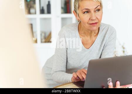 Serene aged short-haired Caucasian woman looking away Stock Photo