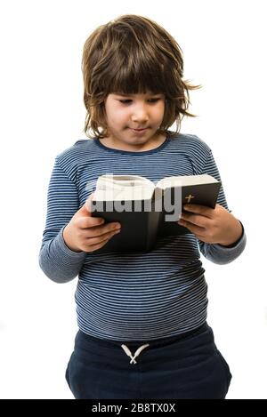 Little boy reading bible isolated on white background Stock Photo