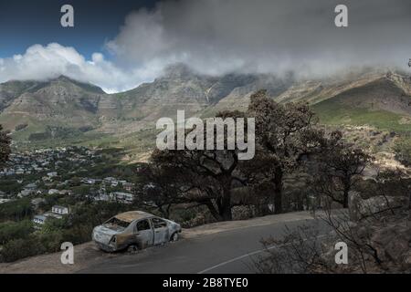 The charred remains of a car caught in a wildfire on the slopes of Cape Town's Lion Head mountain in South Africa Stock Photo