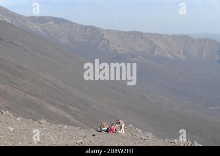 Tourists On The Edge Of Bove Valley In Etna Park, Sicily Stock Photo