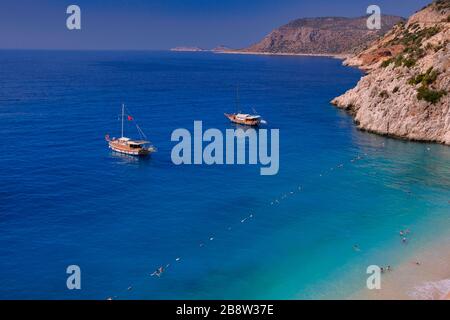 Paradise beach at Kas, Antalya - Turkey. Empty beach with closed umbrellas on Kaputaj Kemer Antalya Turkey beach. Stock Photo