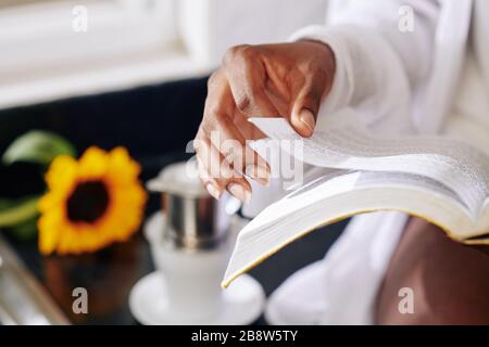 Close-up image of woman turning page of book in her hands Stock Photo