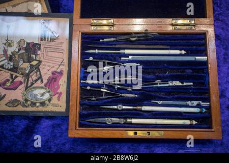 London, UK - 13 February, 2020 Spitalfields flea market. Compasses and drawing accessories in a blue velvet box and old posters. Stock Photo