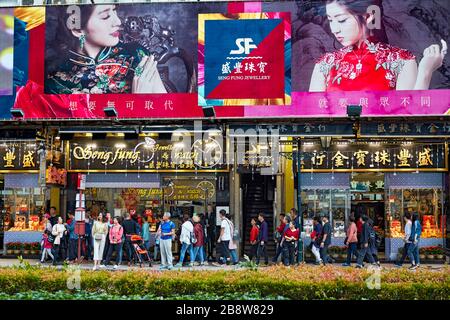 People walking by jewellery shops on the Avenida do Infante Dom Henrique. Macau, China. Stock Photo