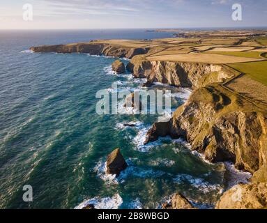 Aerial View of Bedruthan Steps in Cornwall, small secluded beach with steep cliffs and rock stacks offshore. High tide. Stock Photo