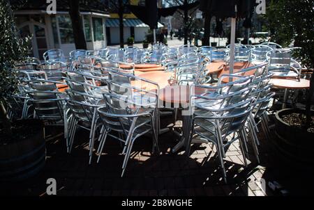 Hanover, Germany. 23rd Mar, 2020. In bright sunshine, shiny chairs are stacked in front of a closed ice cream parlour. Credit: Julian Stratenschulte/dpa/Alamy Live News Stock Photo