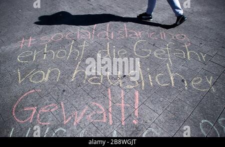 Hanover, Germany. 23rd Mar, 2020. Using chalk, strangers have written on a square in the city center '#socialdistancing increases the risk of domestic violence!' Credit: Julian Stratenschulte/dpa/Alamy Live News Stock Photo