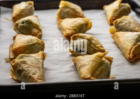 Baked Spanakopita triangles. Stock Photo