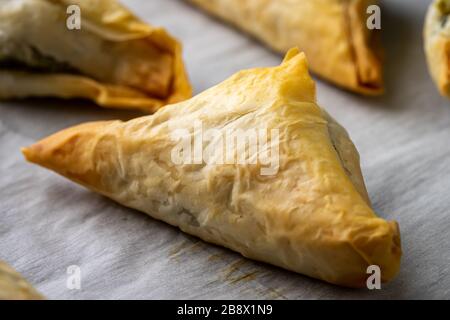 Baked Spanakopita triangles. Stock Photo