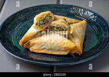 Baked Spanakopita triangles. Stock Photo