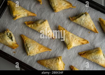 Baked Spanakopita triangles. Stock Photo