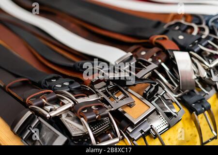 Close up of leather belt buckles at the market. Variety of classic belts for sale Stock Photo