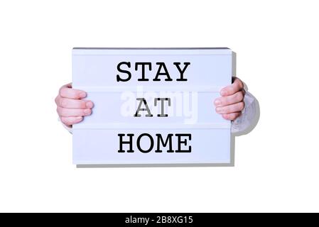 Male hands with Stay At Home sign on white background. Stock Photo