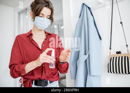 Woman disinfecting hands after coming home. Concept of prevention of virus spread during an epidemic Stock Photo