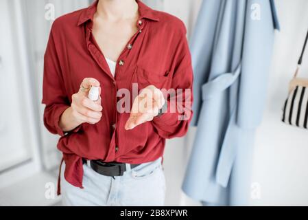 Woman disinfecting hands after coming home, close-up on hands. Concept of prevention of virus spread during an epidemic Stock Photo