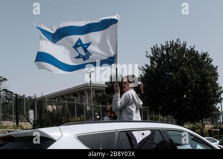 Jerusalem, Israel. 23rd Mar, 2020. The Black Flags Movement brings a convoy of over 1,000 cars to the Knesset, the Israeli Parliament, waving Israeli and black flags, protesting the Netanyahu government's alleged attempt to manipulate legislation and abuse Coronavirus emergency measures in an attempt to ‘hijack' democracy for political and personal benefits. A Supreme Court appeal is now underway aiming to restore the full powers of Parliament, blocked from functioning by Knesset Speaker, Edelstein, a Netanyahu ally. Credit: Nir Alon/Alamy Live News