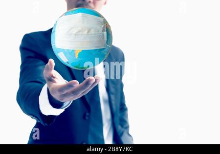 Human hand holding world globe with face mask Concept worldwide for COVID 19 Stock Photo
