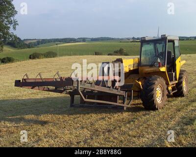 'English: A Matbro TS270 telehandler, somewhere in the United Kingdom presumably. On its front is a flat-8 type bale grab, used to lift 8 small hay or straw square bales of standard size onto trailers. This one was manufactured by Cook Machinery. Also part of the kit is a (bale) sledge that tows behind the baler to line them into 8's (not got a picture though).; 20 June 2005; Own work (Minardi) English: Transferred from en.wikipedia.org [1]: 2006-04-28 09:51 . . Minardi . . 2,032×1,524 (1,004 KB) . . I took this photograph myself of a Matbro TS270 Handler. I release all rights for this file to