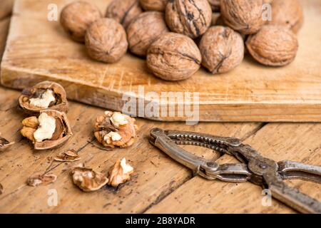 walnuts and nutcracker on an old wooden rustic table - selective focus Stock Photo