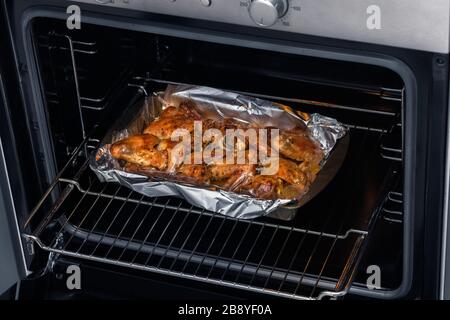Oven baked chicken wings in the home kitchen. With a golden crispy crust. Close-up Stock Photo