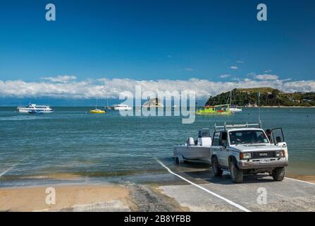 Kaka Ramp Vehicle pulling out boat at ramp, Kaiteriteri Beach over Tasman Bay ...